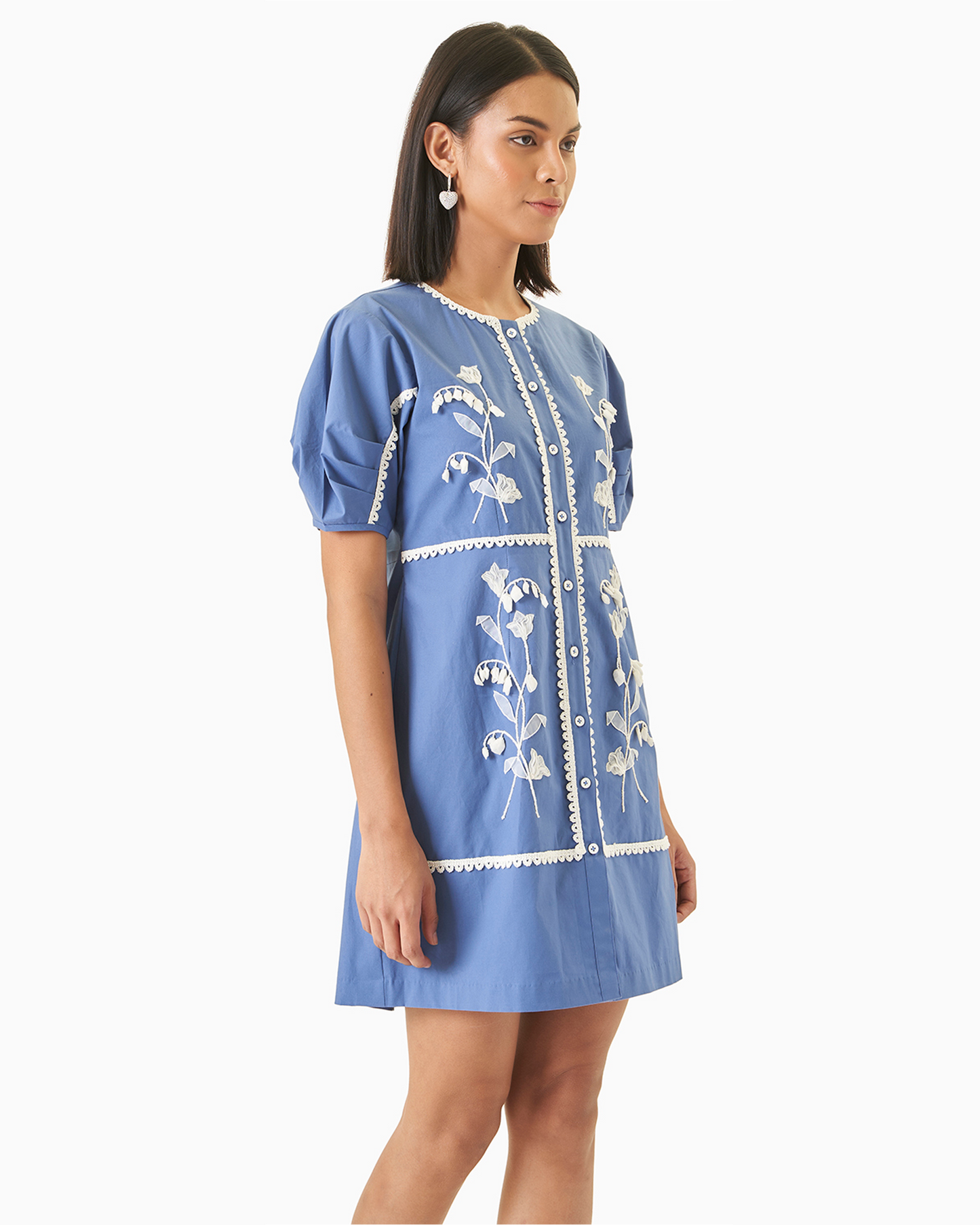 Side view of Daffodil Dress - Blue Cotton Dress featuring puffed ruffle sleeves and intricate white embroidery on soft cotton fabric.